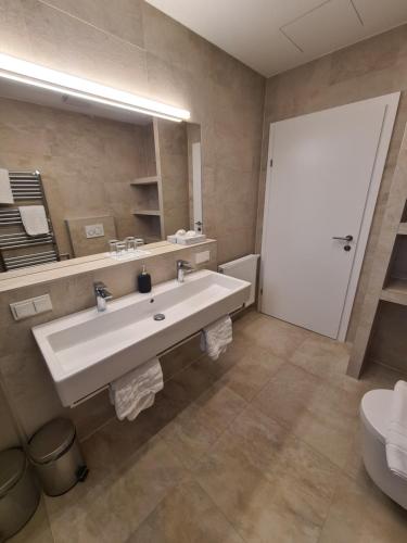 a bathroom with a large white sink and a mirror at Seesuiten Mörbisch in Mörbisch am See