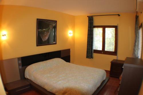 1 dormitorio con cama y ventana en El Cisne - holiday home with private swimming pool in Benissa en Pedramala