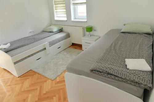 a bedroom with two beds and a window at Dobi Apartmani WING in Jagodina