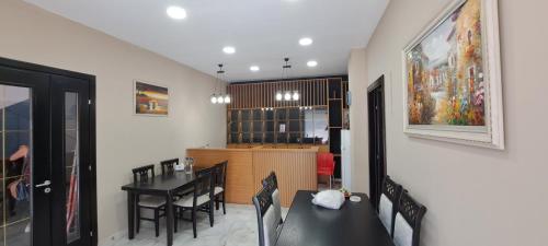a dining room and kitchen with a table and chairs at CityCenterHotel Shkoder in Shkodër