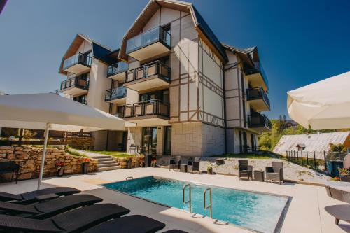 um edifício com piscina em frente a um edifício em Five Seasons Szklarska Poręba em Szklarska Poręba