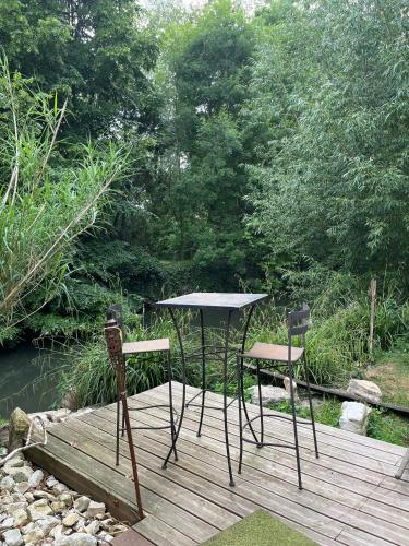 einen Tisch und zwei Stühle auf einer Holzterrasse in der Unterkunft Les Chambres de Marc in Fontenille-Saint-Martin-d'Entraigues