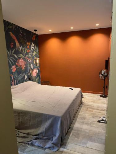 ein Schlafzimmer mit einem Bett mit Blumenwand in der Unterkunft Les Chambres de Marc in Fontenille-Saint-Martin-d'Entraigues