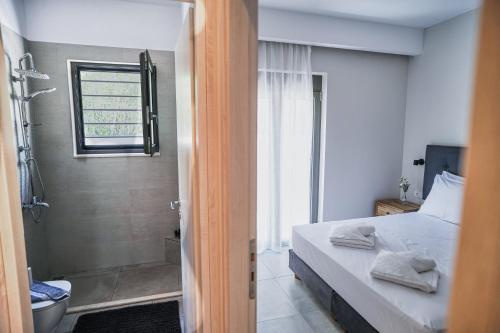 una camera con letto e un bagno con doccia di Sweven boutique apartments a Souda (Suda)