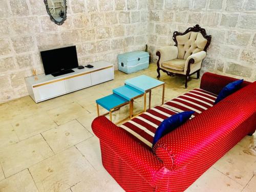 a living room with a red couch and a tv at Serenity 2 in Qormi