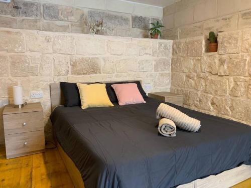 een slaapkamer met een groot bed met kussens erop bij Serenity in Qormi