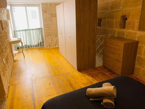 a room with a bed and a dresser in it at Serenity in Qormi