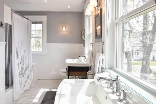 a white bathroom with a sink and a window at Beautifully Renovated in Harwich Center in Harwich