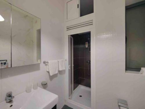 a white bathroom with a sink and a shower at Seaview apartment Sliema in Sliema