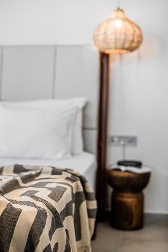 a bedroom with a bed with a lamp next to a bed sidx sidx at King's & Queen's Afitos - Suites With Private Pool in Afitos