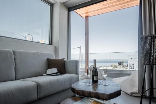 a living room with a couch and a large window at King's & Queen's Afitos - Suites With Private Pool in Afitos