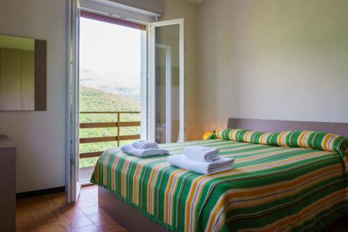 1 dormitorio con 1 cama con toallas en Albergo Payarin, en Ormea