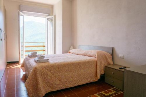a bedroom with a bed and a large window at Albergo Payarin in Ormea