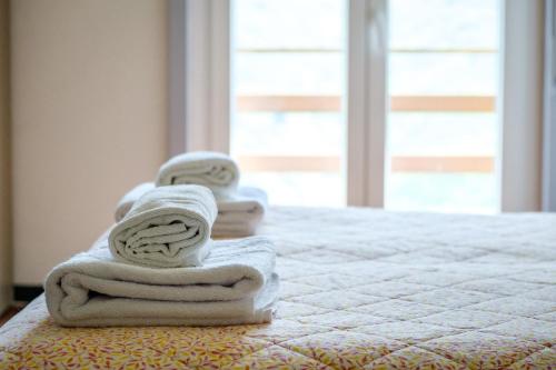 three towels sitting on a bed in a room at Albergo ristorante Payarin in Ormea