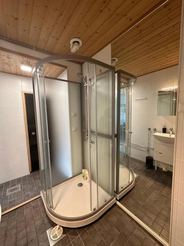a glass shower in a bathroom with a sink at Iiris in Imatra