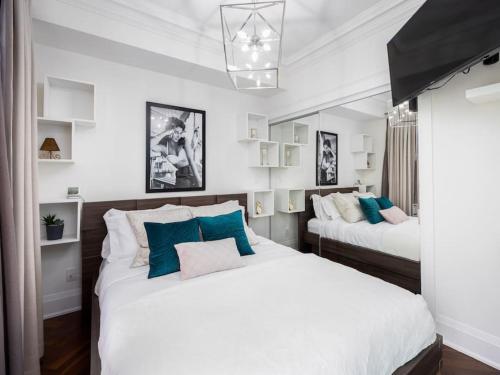 two beds in a room with white and blue at Pristine Modern 2BR Condo Private BBQ and Balcony in Toronto