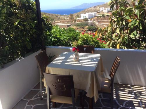 a table on a balcony with a view of the ocean at Blue Sky in Ios Chora