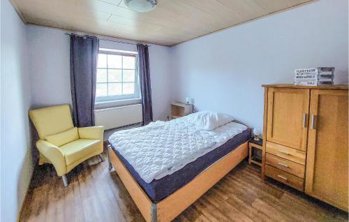 ein Schlafzimmer mit einem Bett, einem Stuhl und einem Fenster in der Unterkunft Lovely Home In Arendsee With Kitchen in Arendsee