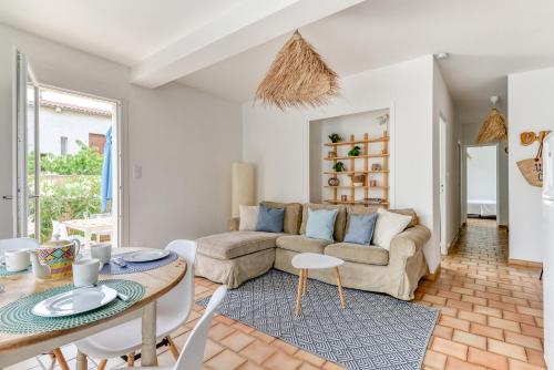 a living room with a couch and a table at Villa Cavi Laurier in Le Grau-dʼAgde