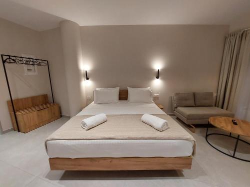 a bedroom with a large bed and a chair at Phoenix Apartments Parga in Parga