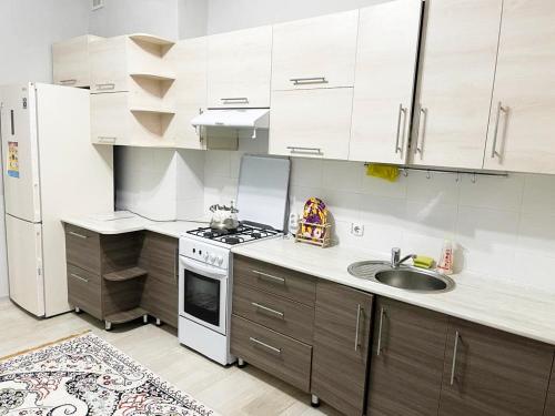 a kitchen with a sink and a white refrigerator at ЖК Астана Просторная 2 х комнатная квартира in Shymkent