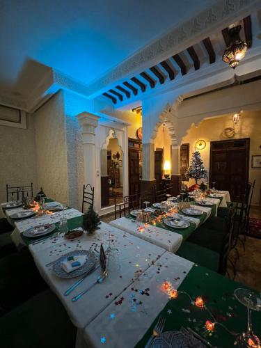 un comedor con mesas largas con adornos navideños en Riad Andalla, en Marrakech