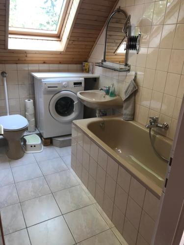 a bathroom with a sink and a tub and a washing machine at Sophie-Haus, Sophie-ház in Balatonmáriafürdő