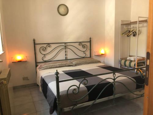 una camera da letto con un letto bianco e nero con un orologio sul muro di Mare Luna Casa a Taormina