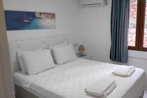 een wit bed met twee witte handdoeken erop bij Cactus Garden Kalkan - Club Patara Villas in Kalkan