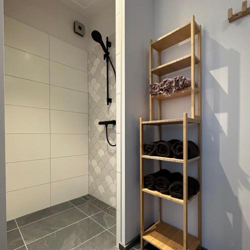 a bathroom with a wooden shelving unit in a room at bedandbreakfastrouveen in Rouveen