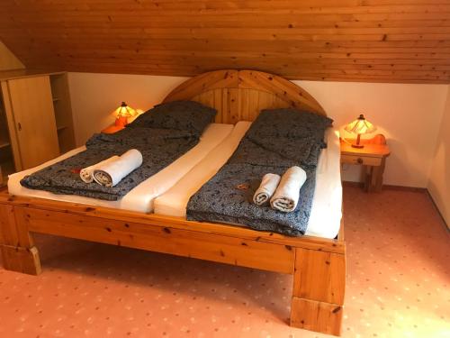ein Schlafzimmer mit einem Holzbett mit zwei Kissen in der Unterkunft Sophie-Haus, Sophie-ház in Balatonmáriafürdő