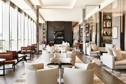 a lobby with white chairs and tables and windows at AC Hotel by Marriott Santiago Costanera Center in Santiago