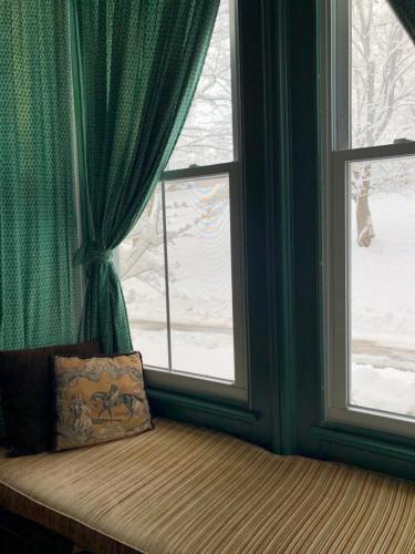 a window seat with a pillow next to a window at Antique Mansion B & B in Rutland