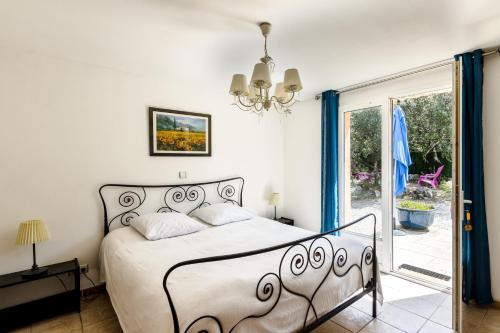 une chambre avec un lit et une porte coulissante en verre dans l'établissement La Rose Des Vents & Spa - Gite Provence, à Néoules