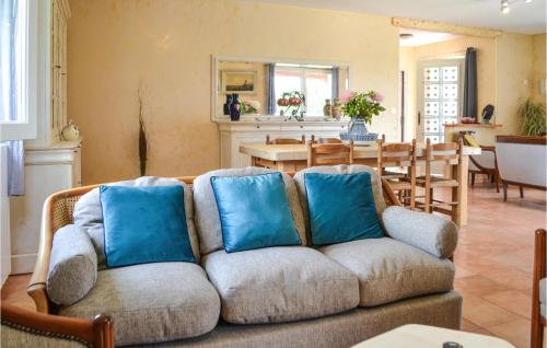 un salon avec un canapé avec des coussins bleus dans l'établissement Cozy Home In Saint-Georges, à Bourlens