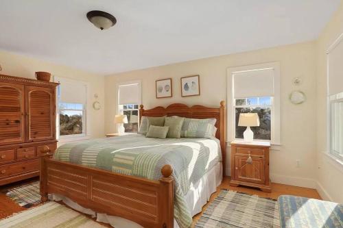 a bedroom with a large bed and two windows at Stunning Home w Incredible Water Views in Chatham