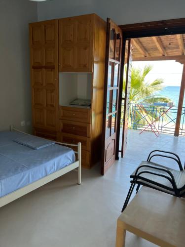 um quarto com uma cama, uma mesa e uma varanda em Villas Nies Seaside Appartments em Soúrpi