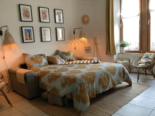 een slaapkamer met een bed en een bank erin bij Studio au pied du phare Vue Mer in Roscoff