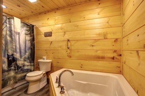 a wooden bathroom with a toilet and a tub at Teddy Bear Cabin in Sevierville