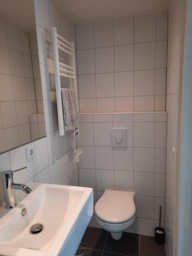 een badkamer met een wit toilet en een wastafel bij luxe ruime studio op unieke, rustige locatie in Dokkum