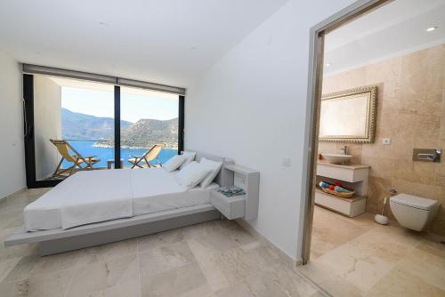 a bedroom with a bed and a view of the ocean at villa ozma in Kaş