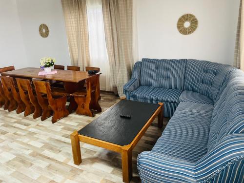 a living room with a blue couch and a table at Blue Sky Transalpina in Săsciori