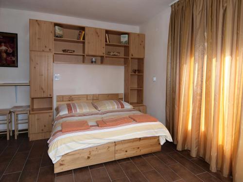een slaapkamer met een houten bed in een kamer bij Sárréti Apartmanház in Balatonfüred