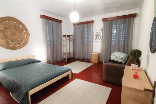 ein Schlafzimmer mit einem Bett und einer Couch in einem Zimmer in der Unterkunft Casa das Hortas in Vila Franca do Campo