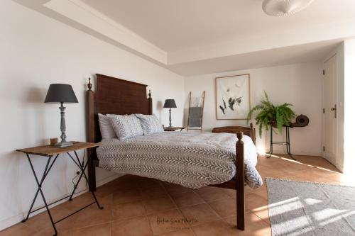 フォス・ド・アレーリョにあるSunshine Guest Houseのベッドルーム(ベッド1台、テーブル、ランプ付)