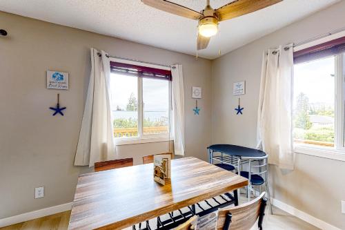 a dining room with a wooden table and two windows at Bonnie's Bayview Beach House in Bay City