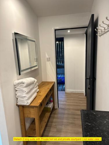 a bathroom with a mirror and a table with towels at TheWaterfrontLodges in Coventry