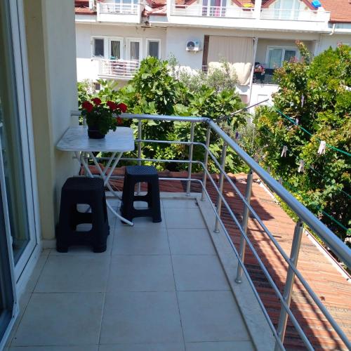 a balcony with a table and two stools on it at двухкомнатная уютная квартира недалеко от пляжа in Fethiye