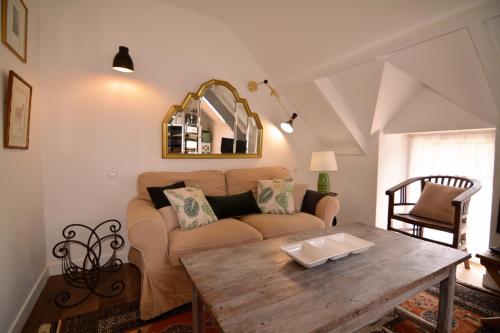 een woonkamer met een bank en een tafel bij Le Moulin De Branféré. in Le Guerno