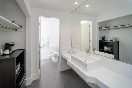 Un baño blanco con lavabo y espejo. en Beck's Motor Lodge, en San Francisco